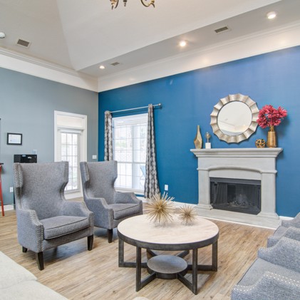 A view of the leasing office at Preston Hill with two grey  chairs and a table.